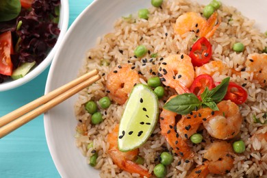 Photo of Tasty rice with shrimps and vegetables on light blue table, flat lay