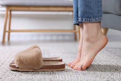Photo of Woman near brown soft slippers at home, closeup