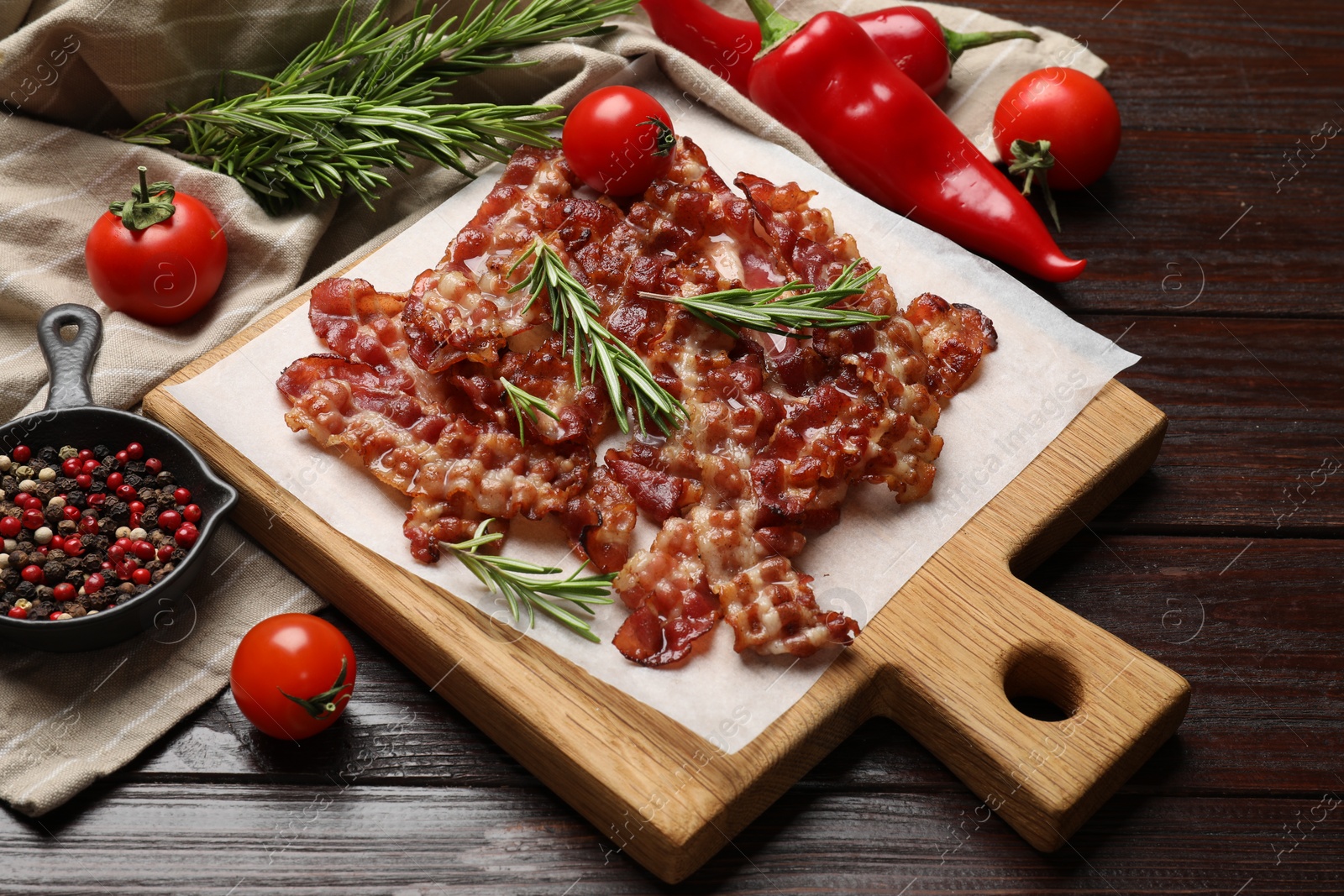 Photo of Slices of tasty fried bacon, tomatoes and different spices on wooden table, top view