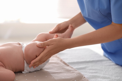 Doctor examining cute baby in clinic, closeup. Health care