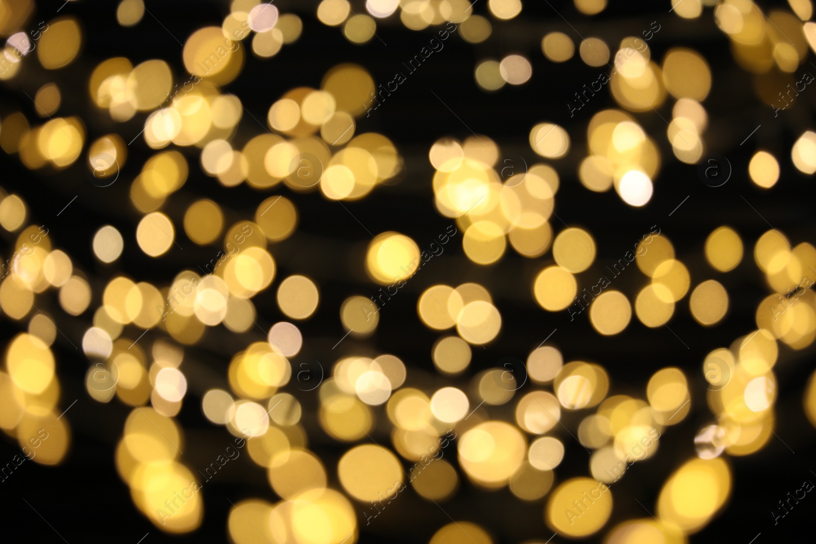 Photo of Golden blurred lights on black background. Bokeh effect