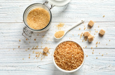 Jar and bowl with brown sugar on wooden table