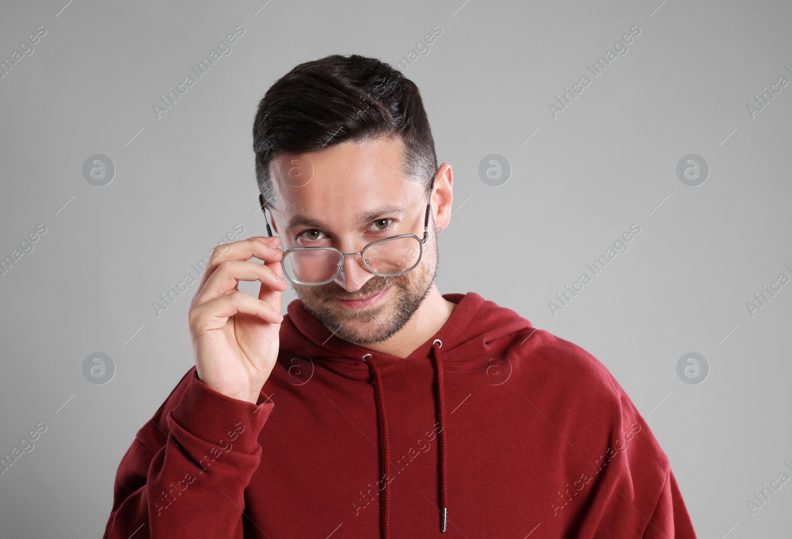 Photo of Portrait of happy man in stylish glasses on light grey background