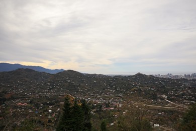 Photo of Cloudy sky over mountain valley with houses. Picturesque view