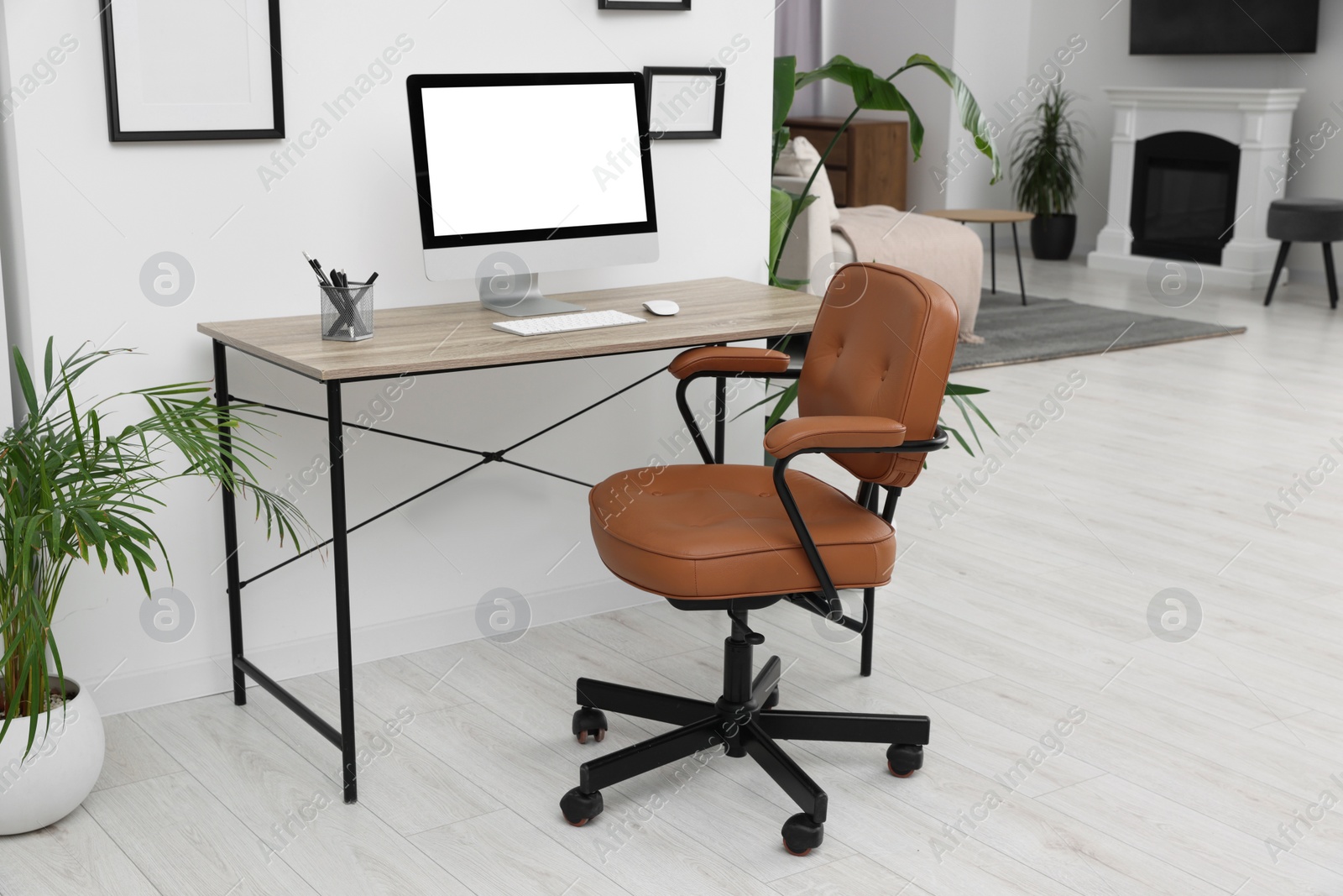 Photo of Stylish room interior with comfortable office chair, desk and houseplants