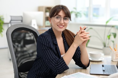 Photo of Portrait of smiling secretary at table in office