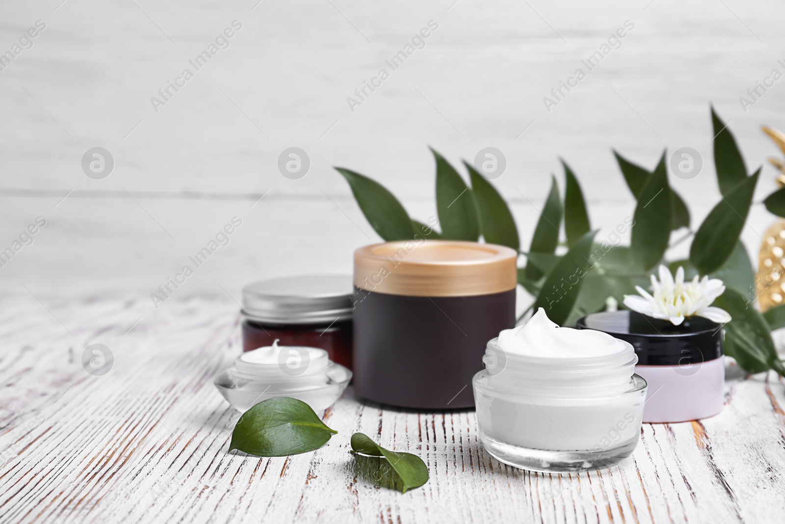 Photo of Composition with body cream in jars on light background