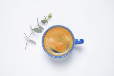 Coffee in cup and eucalyptus on white background, top view. Color of the year 2020 (Classic blue)