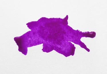 Photo of Blot of purple ink on white background, top view