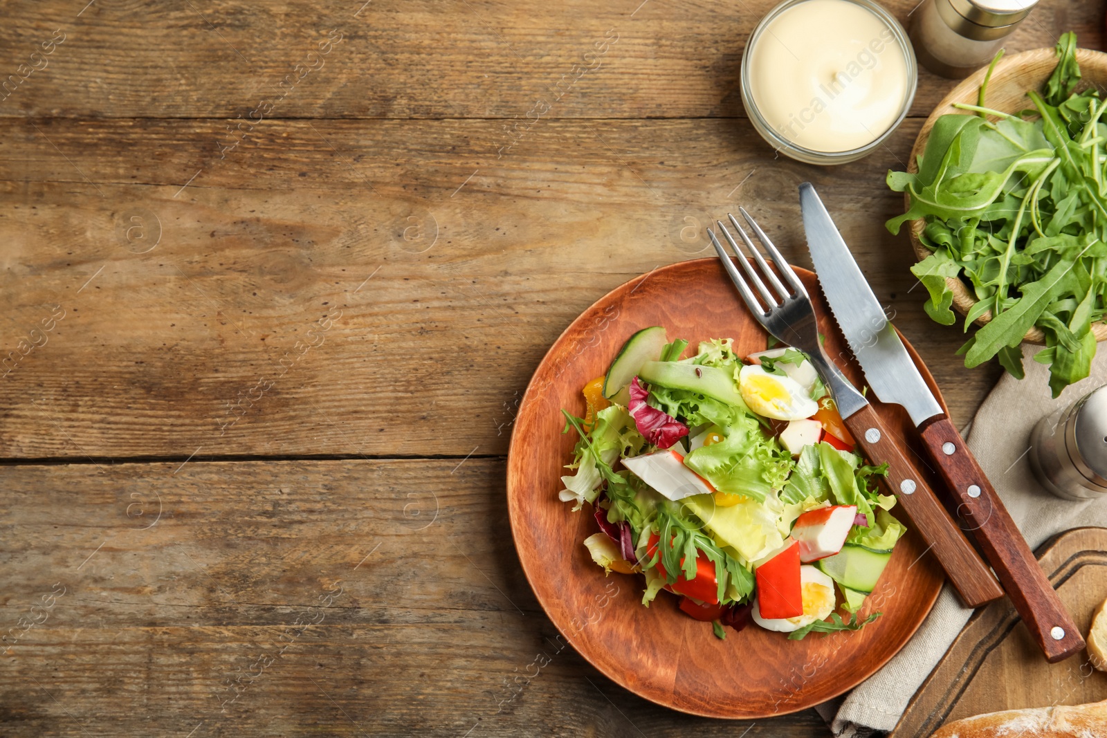 Photo of Delicious salad with lettuce served on wooden table, flat lay. Space for text