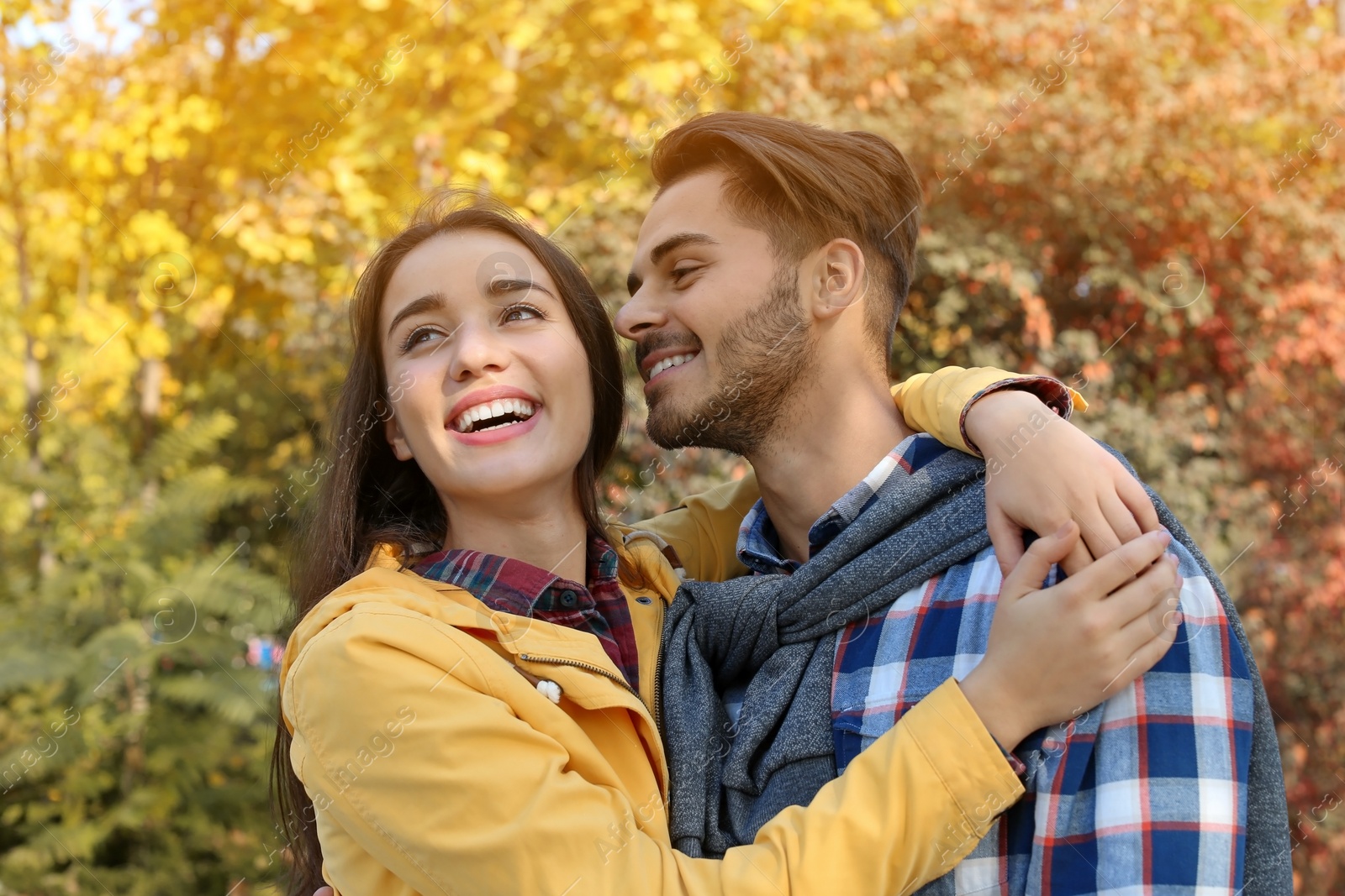 Photo of Young lovely couple spending time together in park. Autumn walk