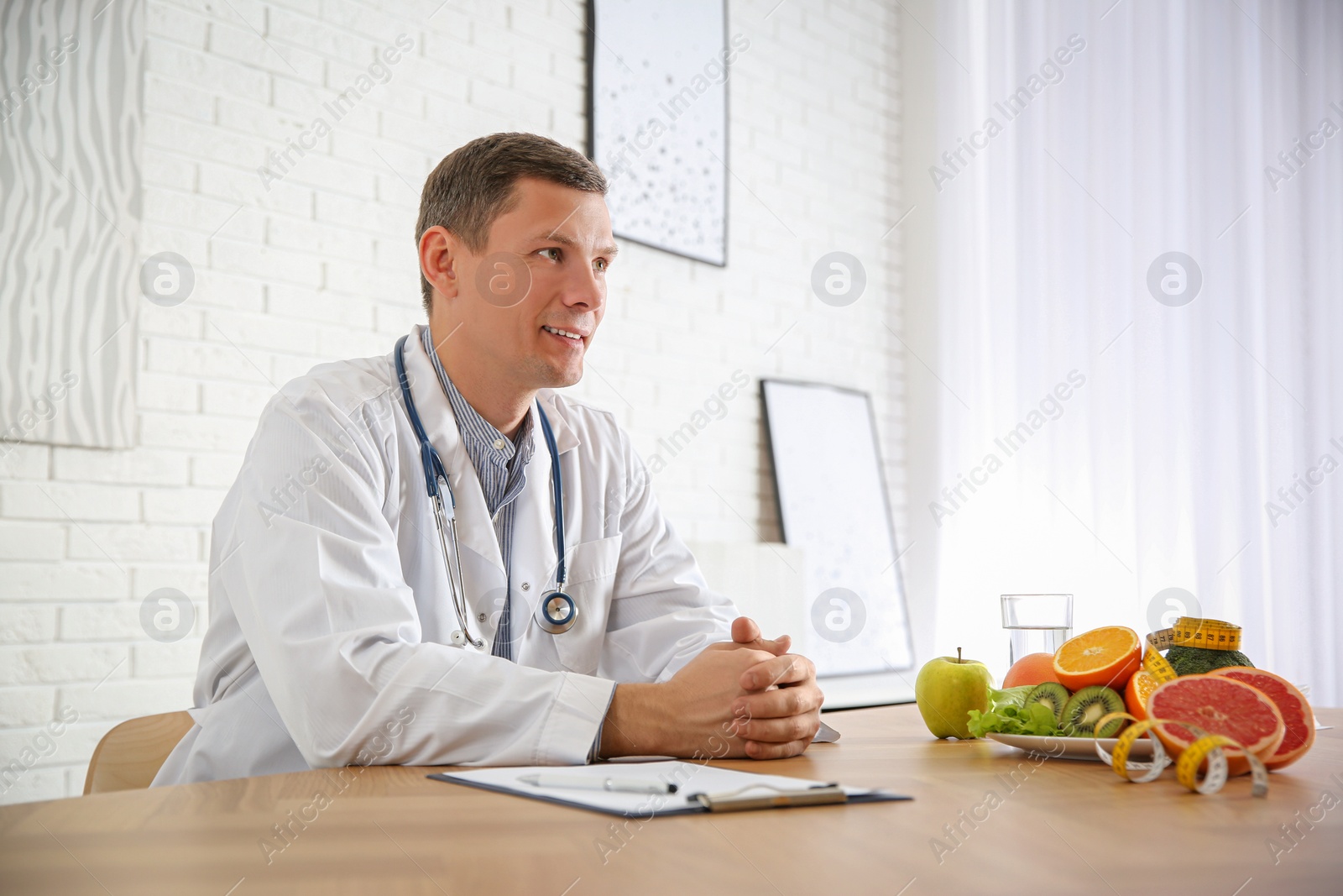 Photo of Nutritionist with clipboard at desk in office