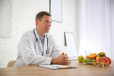 Photo of Nutritionist with clipboard at desk in office