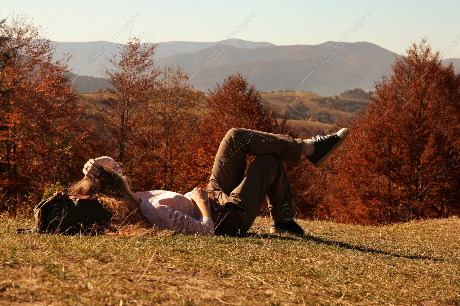 Photo of Woman in warm clothes relaxing on mountain slope