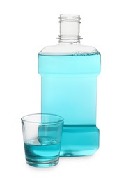 Photo of Bottle and glass with mouthwash on white background