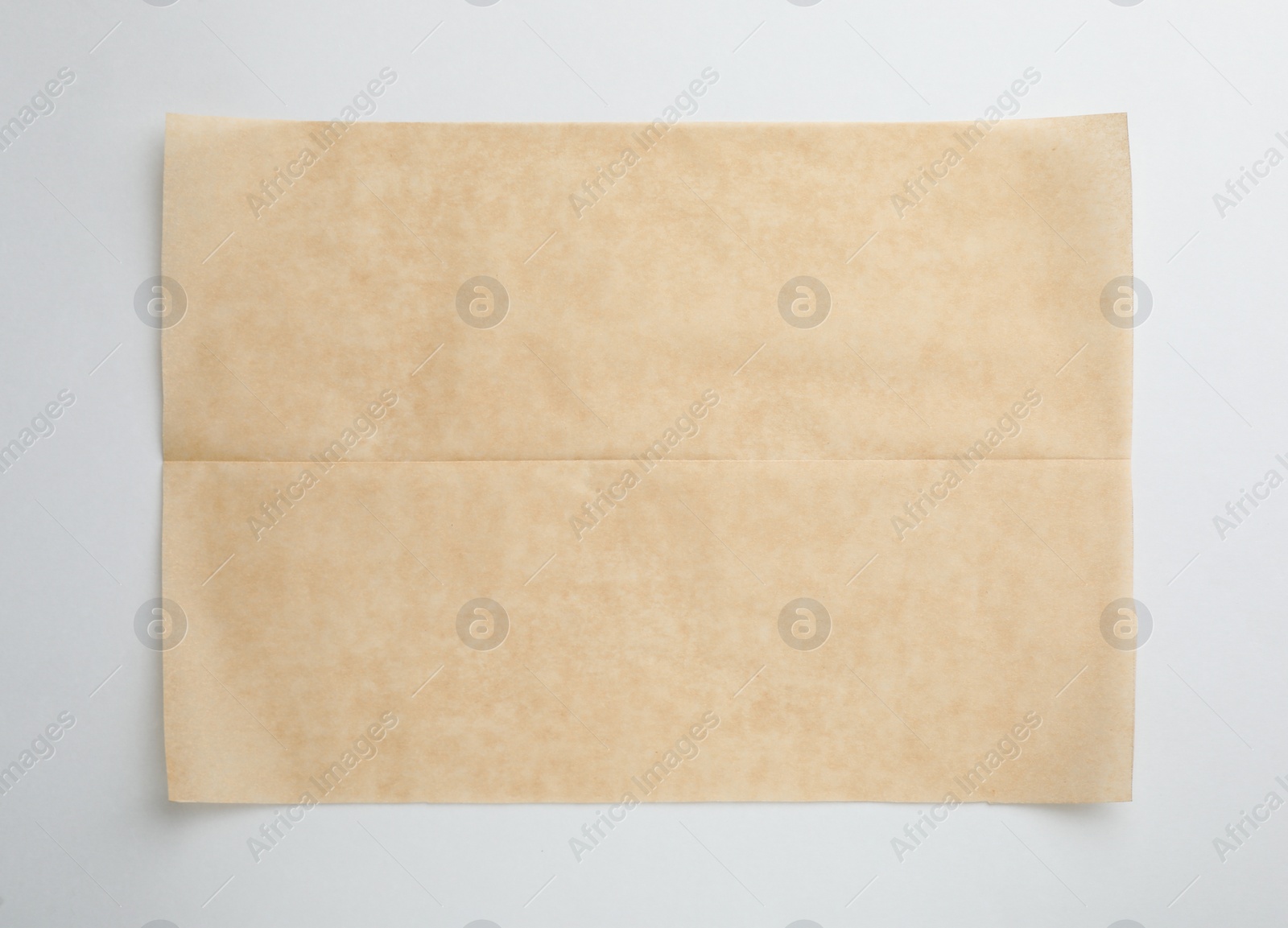 Photo of Sheet of brown baking paper on white background, top view