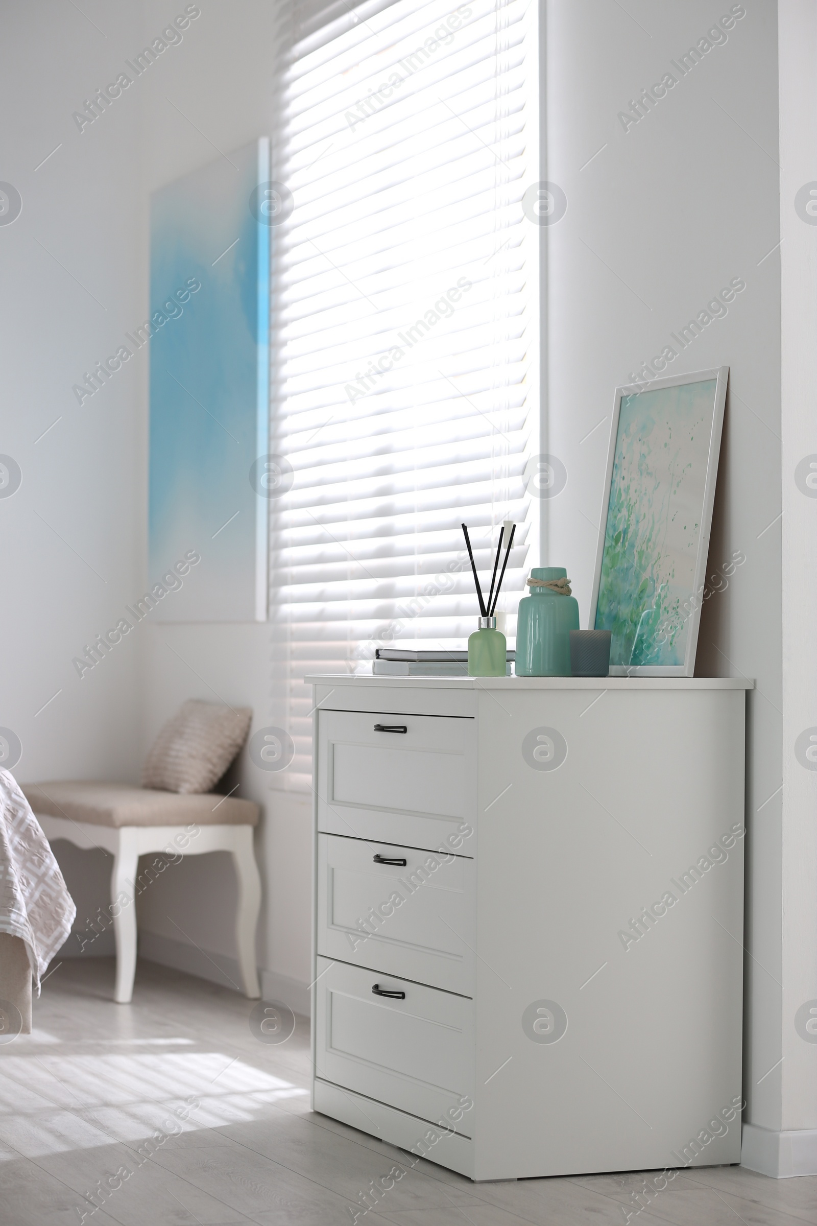 Photo of Modern room interior with white chest of drawers