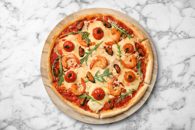 Photo of Delicious seafood pizza on white marble table