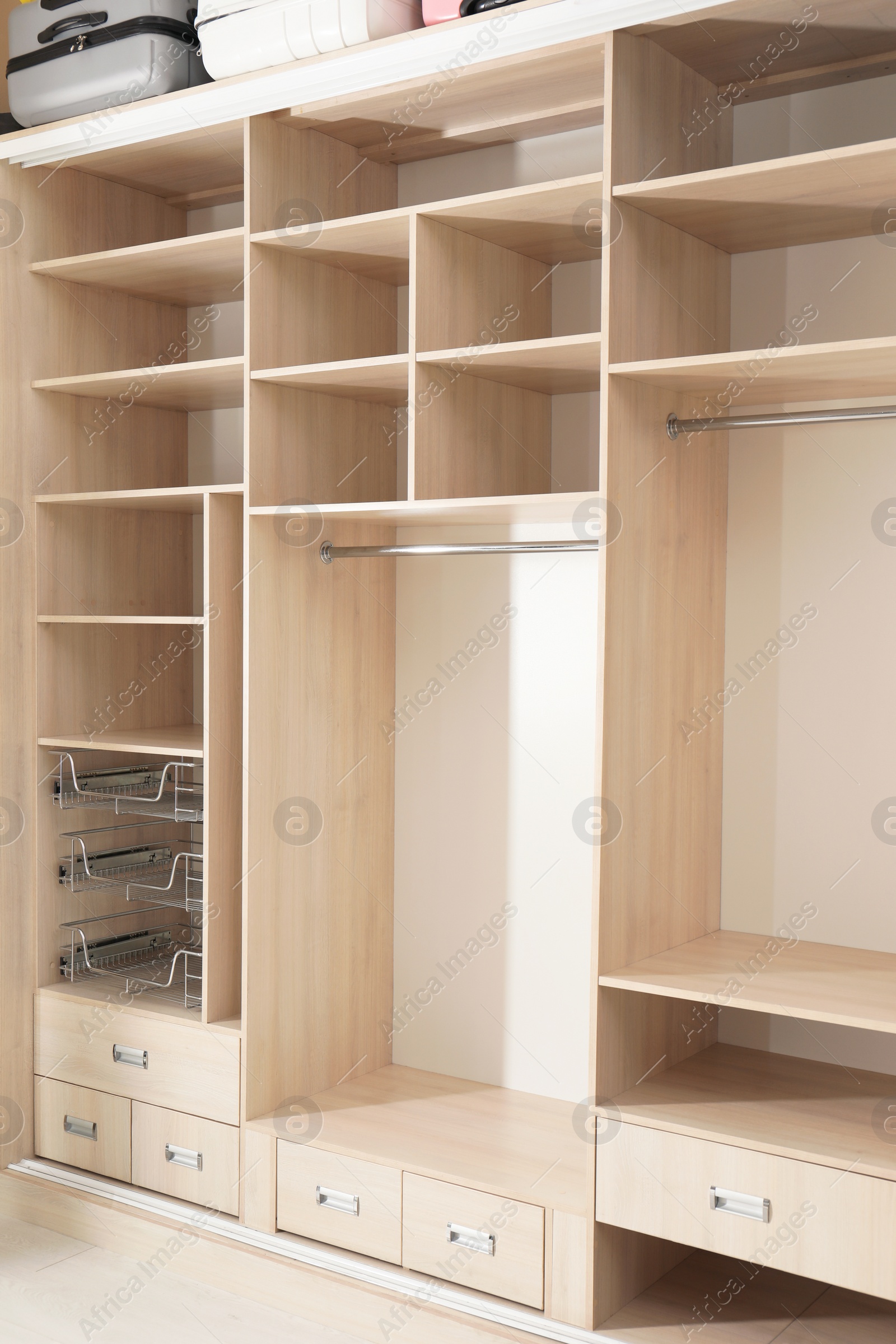 Photo of Empty wooden wardrobe with shelves and drawers in dressing room