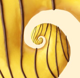 Image of Twisted donut with banana icing and chocolate topping on beige background, spiral effect