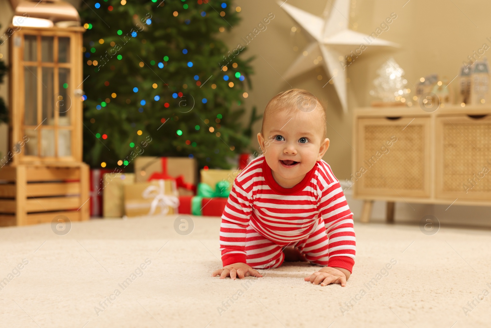 Photo of Cute little baby in room decorated for Christmas. Winter holiday