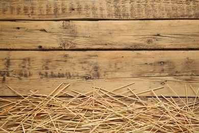 Dried hay on wooden background, flat lay. Space for text