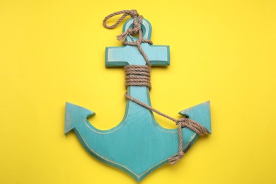Photo of Wooden anchor figure on yellow background, top view