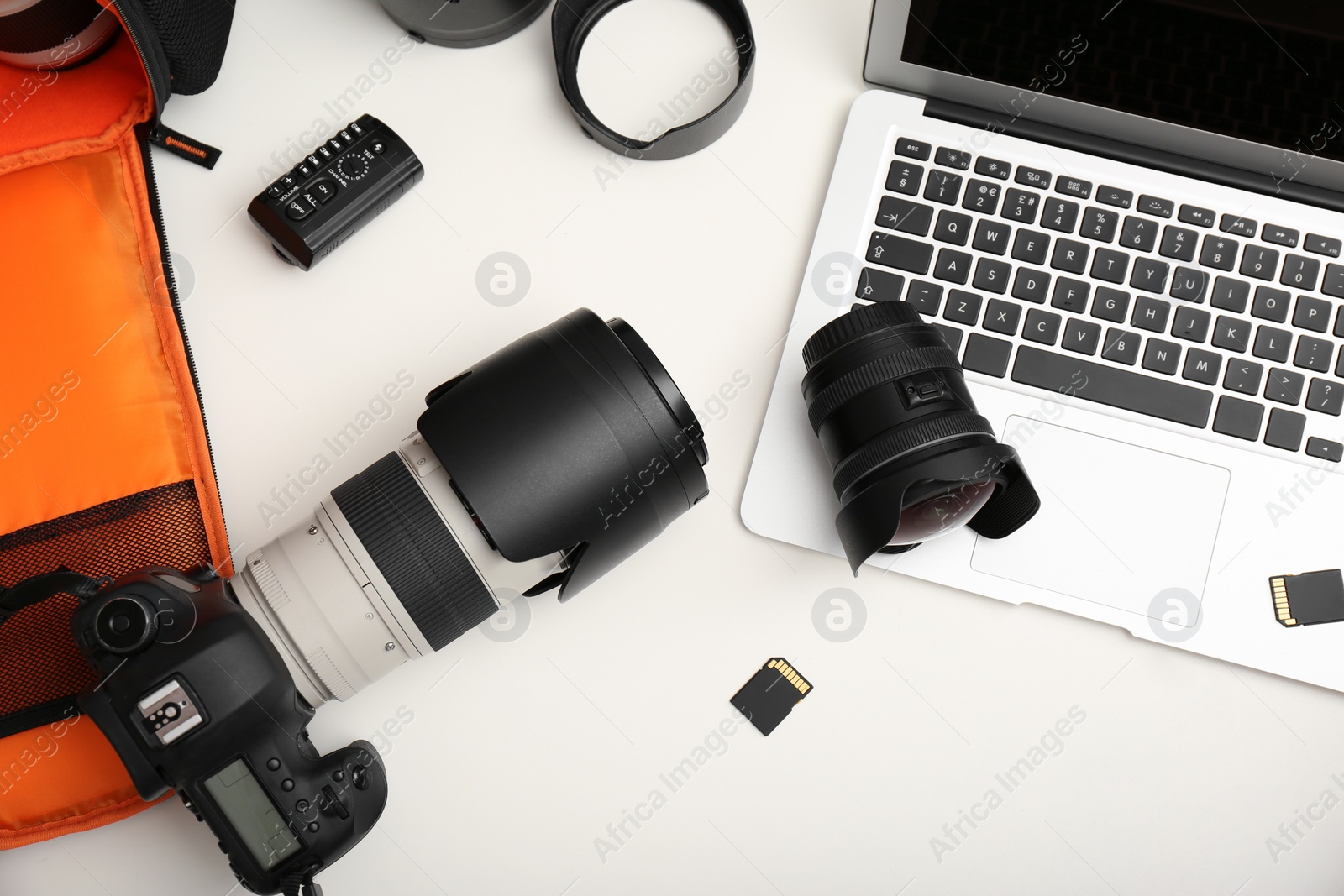 Photo of Laptop and professional photographer's equipment on table, top view