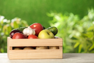 Photo of Wooden crate with fresh vegetables and fruits on table outdoors, space for text