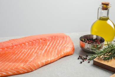 Fresh raw salmon and ingredients for marinade on grey table