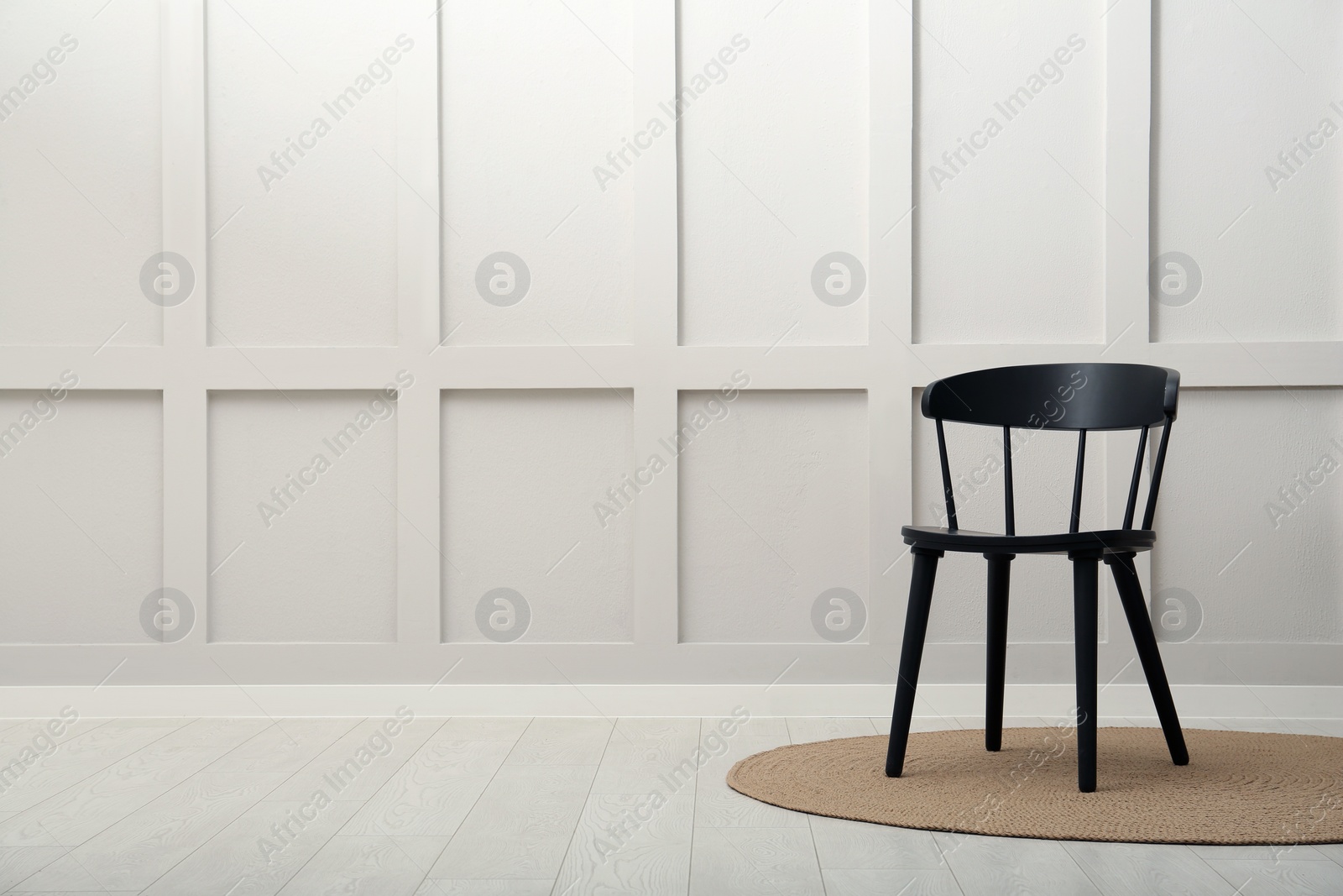 Photo of Black wooden chair near white wall indoors. Space for text