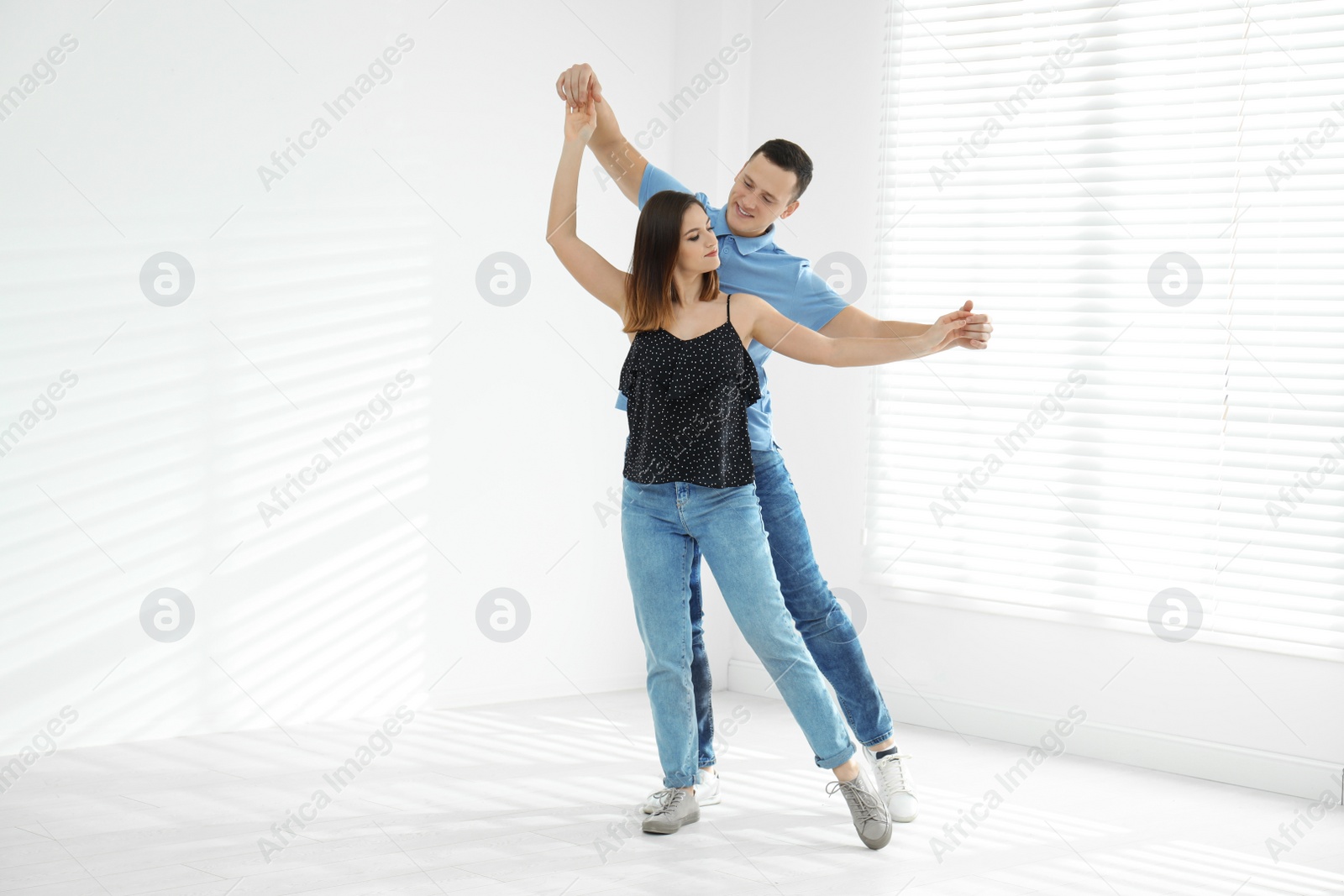 Photo of Beautiful young couple dancing in empty studio