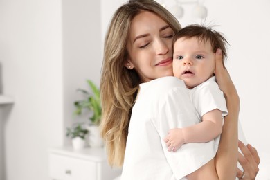 Photo of Mother hugging her cute little baby in room