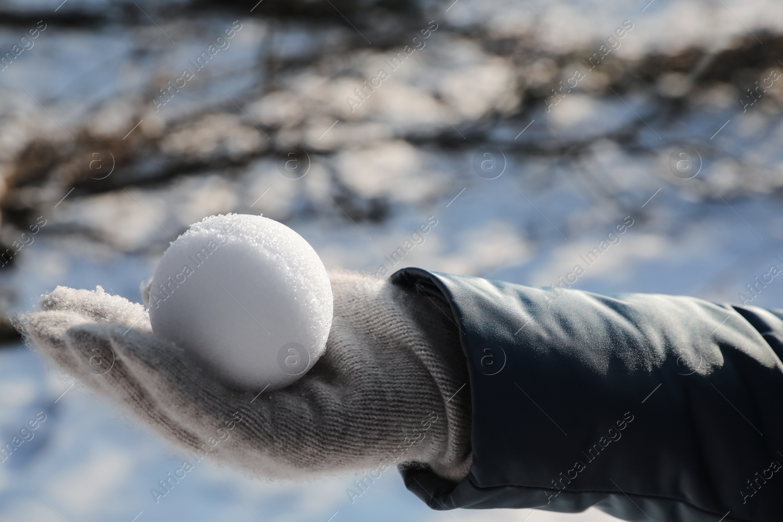 Photo of Woman holding snowball outdoors on winter day, closeup. Space for text