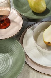 Stylish ceramic plates, glass and pears on white marble table