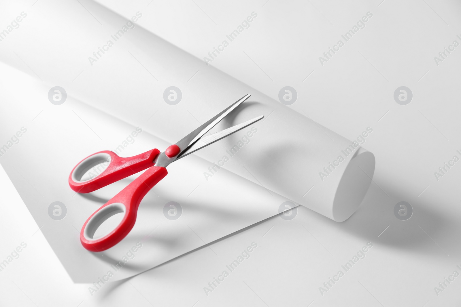 Photo of Red scissors and paper on white background