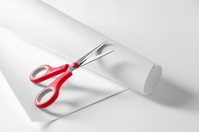 Photo of Red scissors and paper on white background