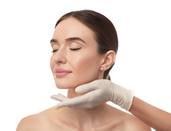 Photo of Doctor examining woman's face before plastic surgery on white background