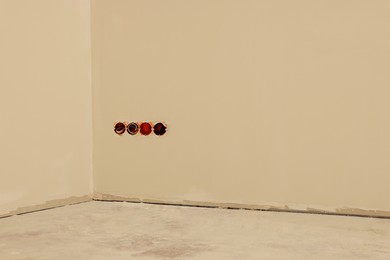 Photo of Holes for socket in beige clean wall