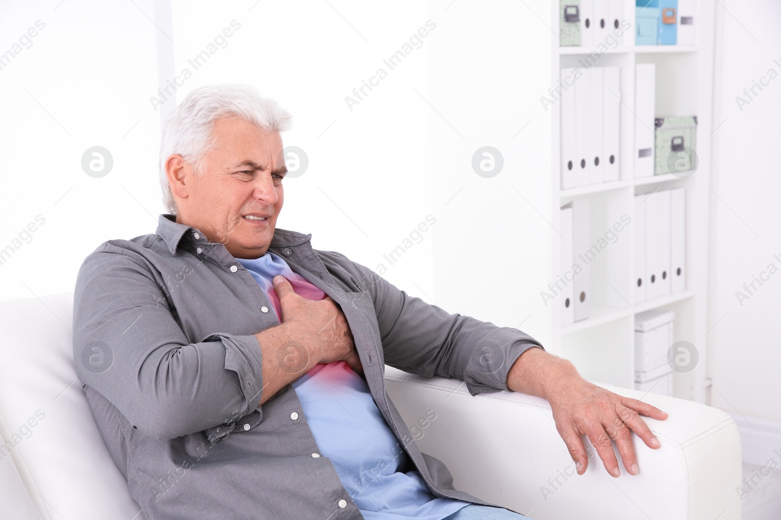 Photo of Senior man having heart attack on sofa