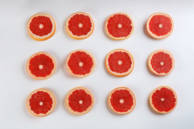 Photo of Flat lay composition with tasty ripe grapefruit slices on white background