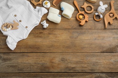 Flat lay composition with baby clothes and accessories on wooden background, space for text