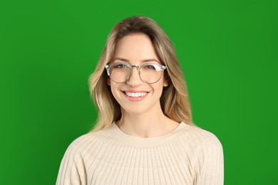 Image of Chroma key compositing. Happy young woman smiling against green screen