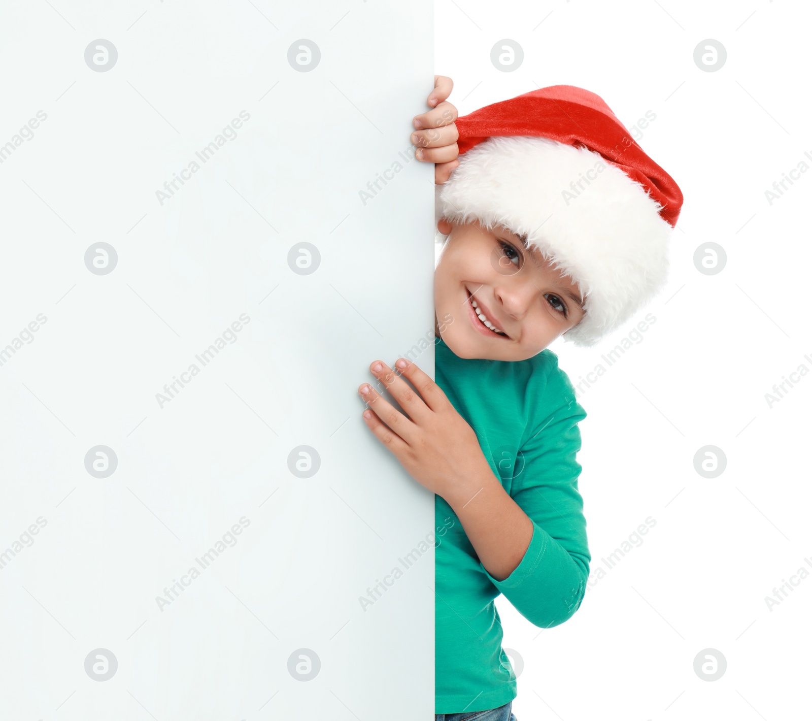 Photo of Cute little child wearing Santa hat on white background. Christmas holiday