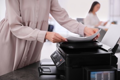 Employee using modern printer in office, closeup