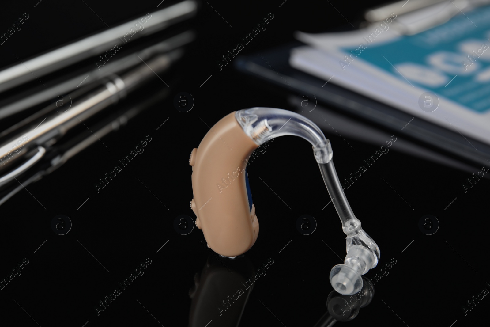 Photo of Hearing aid on black table. Medical device