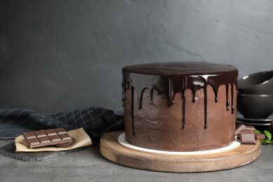 Photo of Freshly made delicious chocolate cake on grey table. Space for text