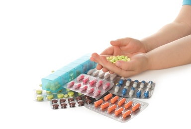 Little child with many different pills on white background, closeup. Danger of medicament intoxication