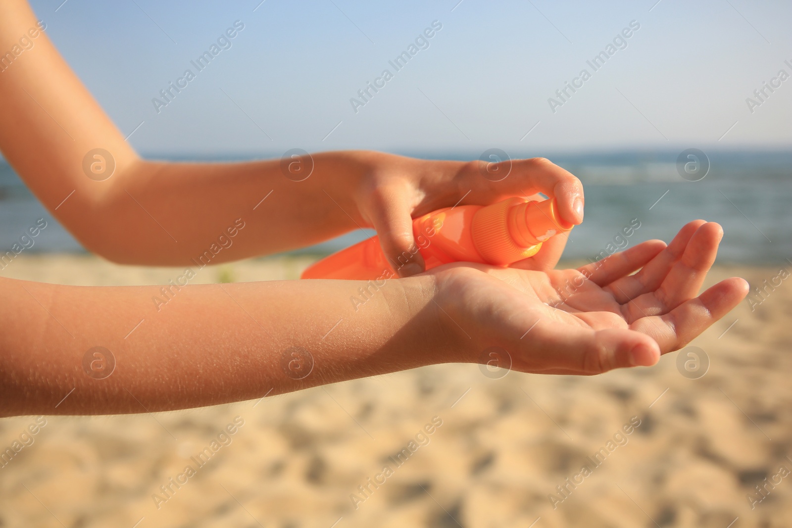 Photo of Child applying sunscreen near sea, closeup. Sun protection care