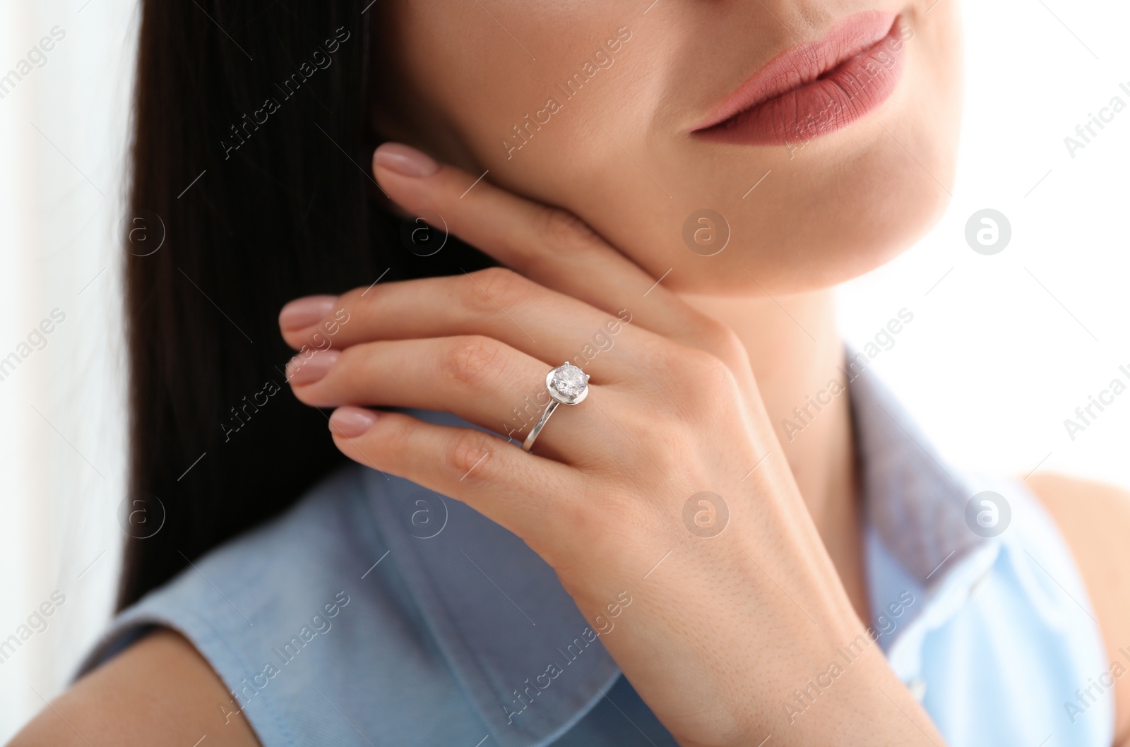 Photo of Young woman wearing beautiful engagement ring, closeup